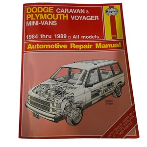 May include: A Haynes Automotive Repair Manual for Dodge Caravan and Plymouth Voyager mini-vans, covering models from 1984 to 1989. The cover features a red background with a white illustration of a minivan with the text "Every manual based on a complete teardown and rebuild".