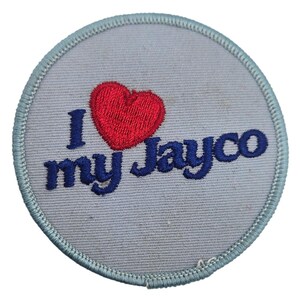 May include: A circular embroidered patch with a light gray background and a light blue stitched border. The patch features the text I in dark blue, a red embroidered heart symbol, and the text my Jayco in dark blue lettering.