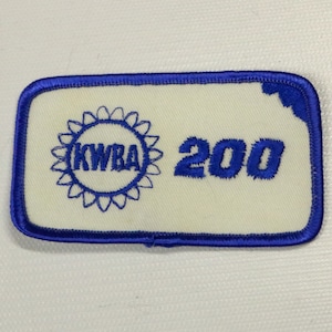 May include: Blue and white embroidered patch with a sunburst design and the text "KWBA 200".