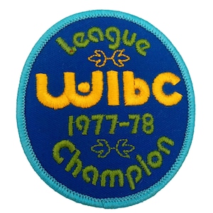 May include: A blue and turquoise circular patch with the text "League WJIBC 1977-78 Champion" in yellow and green embroidery.