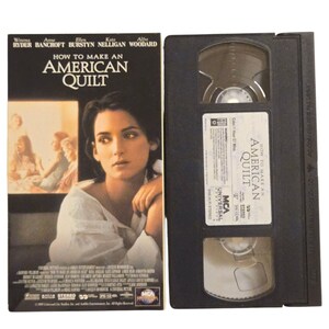May include: A VHS tape and its cover for the movie "How to Make an American Quilt." The cover features Winona Ryder and the movie title in large white letters. The VHS tape is black with a white label.