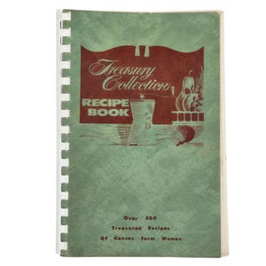 Könnte beinhalten: Ein Vintage-Kochbuch mit dem Titel "Treasury Collection Recipe Book" mit grünem Einband und Spiralbindung. Das Cover zeigt ein weinrotes Banner mit dem Titel in eleganter Schrift und Illustrationen von Lebensmitteln. Das Buch enthält über 300 geschätzte Rezepte.