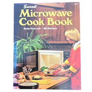 May include: A vintage cookbook titled "Sunset Microwave Cook Book" with the text "Basic How-to's • 184 Recipes." The cover features a woman in a red outfit using a microwave. The image includes a microwave, food, and kitchen utensils.