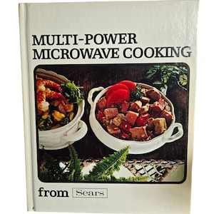 May include: A white cookbook with the title "Multi-Power Microwave Cooking from Sears" on the cover. The cover features a photo of two white bowls filled with food, one with shrimp and vegetables and the other with a stew.