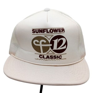 May include: White mesh trucker hat with a brown and white logo that says "Sunflower Classic" and a brown "F" and a maroon "12" inside a circle.