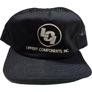 Puede incluir: Gorra de camionero negra de malla con un logotipo blanco que dice "Lippert Components, Inc." y un círculo blanco con las letras "L" y "9" dentro.