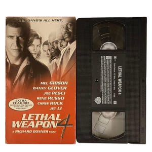 May include: VHS video cassette tape of the movie Lethal Weapon 4, featuring Mel Gibson, Danny Glover, Joe Pesci, Rene Russo, Chris Rock, and Jet Li. The cover is red with the title in white and black text. The gang's all here.