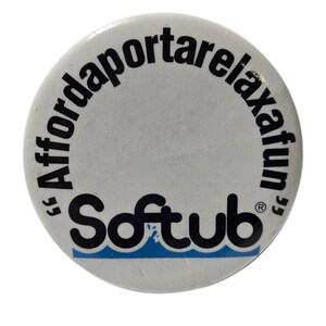 Könnte beinhalten: Ein runder, weißer Knopf mit dem Text "Affordarelaxafun" in Schwarz, der sich oben wölbt. Das Wort "Softub" steht in fetter, schwarzer Schrift unten, mit einem blauen Wellenmuster darunter.