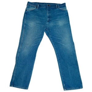 Puede incluir: Un par de pantalones vaqueros azules de mezclilla con corte recto. Los vaqueros tienen un dise&ntilde;o cl&aacute;sico de cinco bolsillos y cierre de bot&oacute;n.