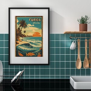 May include: A framed vintage-style poster with a blue, green, and orange color scheme. The poster features a beach scene with palm trees, a surfer, and the text "Florida, Peninsula".