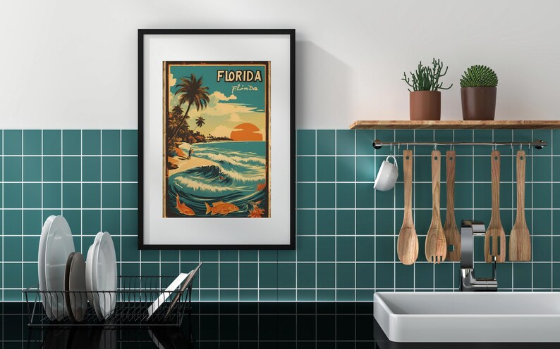 May include: A framed vintage-style poster with a blue, green, and orange color scheme. The poster features a beach scene with palm trees, a surfer, and the text "Florida, Peninsula".