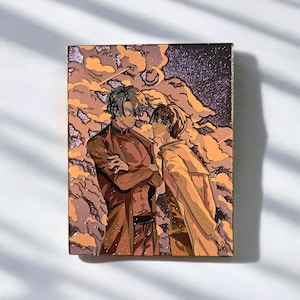 May include: A rectangular enamel pin depicting two anime-style figures in a romantic embrace, set against a backdrop of orange and purple clouds. The figures are dressed in brown and tan clothing. The pin has a glittery border.