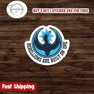 Może przedstawiać: Biała naklejka z niebiesko-czarnym wzorem ptaka i napisem "REBELLIONS ARE BUILT ON 'OPE". Naklejka zawiera r&oacute;wnież tekst "BUY 5 GET 1 STICKER 2X2 FOR FREE" i "Fast Shipping".