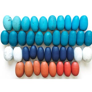 Puede incluir: Un juego de tres tazas de cerámica con un acabado mate moteado. Las tazas son de color crema, gris claro y gris oscuro. Cada taza tiene un diseño simple y minimalista y un asa redondeada.