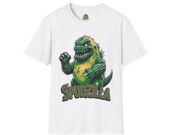 May include: A white short-sleeve t-shirt featuring a graphic of a green, potato-like monster with sharp teeth and red eyes. Below the creature, the text SPUDZILLA is printed in a bold, dark olive green font with a subtle shadow effect.