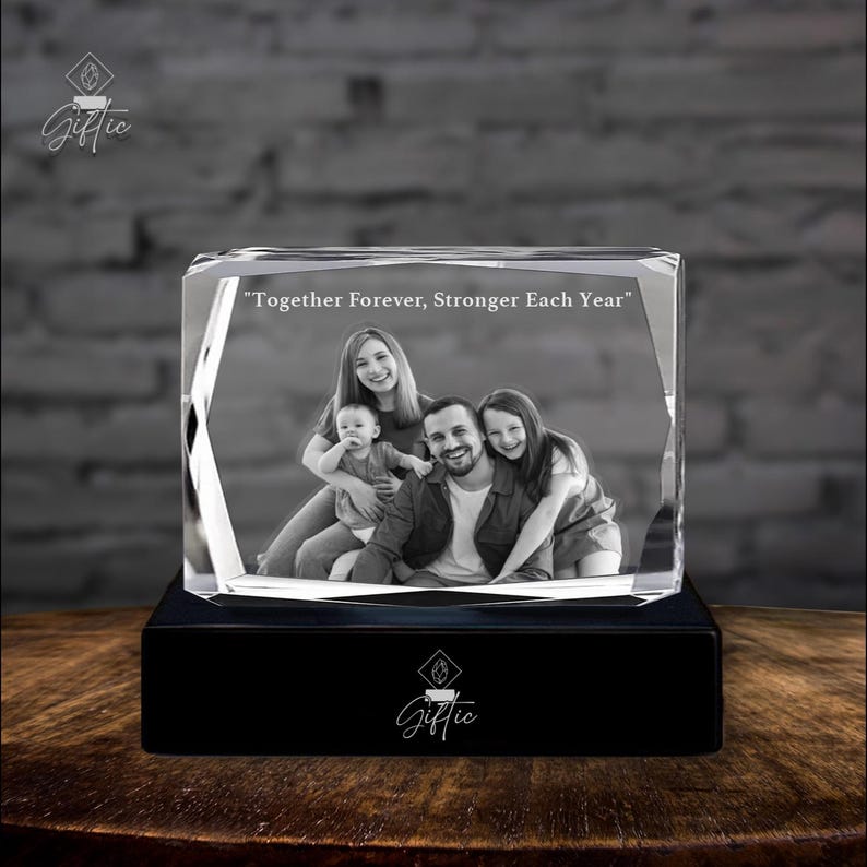 Op de afbeelding: Een zwart-witfoto van een gezin van vier personen is gegraveerd in een kristallen kubus. De kubus staat op een zwarte basis. De tekst "Together Forever, Stronger Each Year" is gegraveerd in de kristallen kubus.