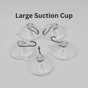 May include: Five clear plastic suction cups with metal hooks. The suction cups are large and round. The hooks are silver and have a loop at the end. The text "Large Suction Cup" is printed above the suction cups.