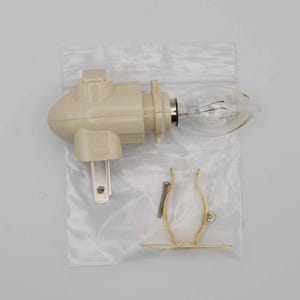 May include: A beige night light with a clear light bulb and a metal clip for mounting. The night light has a standard two-prong plug.
