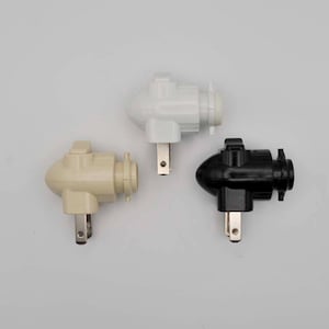 May include: Three electrical outlet adapters in white, beige, and black. Each adapter has a standard two-prong plug and a single light bulb socket.