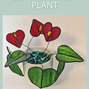 May include: A 3D stained glass Anthurium plant with red heart-shaped flowers and green leaves. The flowers have yellow centers and are in a white pot filled with blue-green stones. The text "3D ANTHURIUM PLANT" is at the top.
