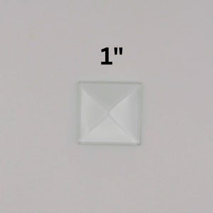 May include: A white, 1-inch square pyramid-shaped embellishment.