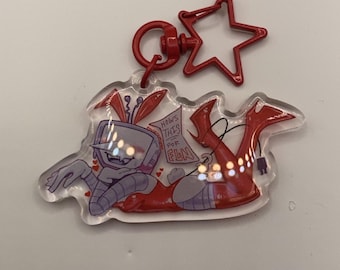 May include: A clear acrylic keychain featuring a cartoon robot character in red and purple. The keychain has a red star-shaped clasp and a red circular clasp. The robot has a TV screen head and the text "How's This For Fun".