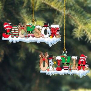 Puede incluir: Dos adornos navide&ntilde;os personalizados con los nombres JACKSON y OLIVIA en letras festivas. Cada letra incorpora personajes como Santa, renos, elfos y mu&ntilde;ecos de nieve, sobre una base nevada con cordones dorados para colgar.