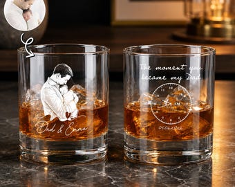 Puede incluir: Dos vasos de whisky transparentes llenos de hielo y líquido ámbar. Un vaso presenta una imagen grabada de un padre sosteniendo a un bebé, con el texto "Dad & Emma". El otro vaso tiene el texto "The moment you became my Dad" y un diseño de reloj.