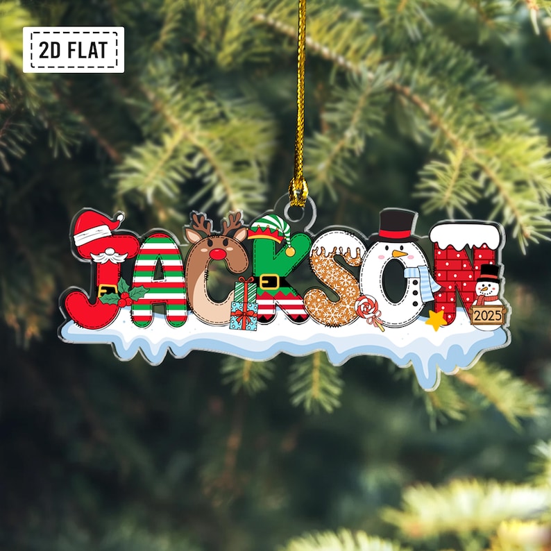 Puede incluir: Un adorno navide&ntilde;o plano para colgar con el nombre JACKSON en letras festivas. Cada letra incorpora motivos estacionales como Santa, renos, elfos, copos de nieve, un mu&ntilde;eco de nieve y una chimenea con el a&ntilde;o 2025 impreso en ella.