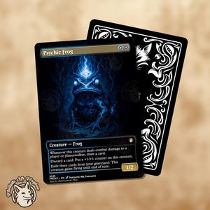 May include: A trading card featuring a blue psychic frog illustration with a third eye. The card is titled "Psychic Frog" and has a black background with white text. The back of the card is black with a white decorative design.