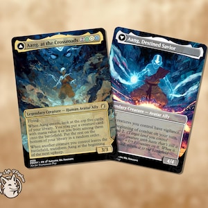 Può includere: Due carte collezionabili con opere d'arte di Aang da Avatar: The Last Airbender. Una carta è intitolata "Aang, at the Crossroads" e l'altra "Aang, Destined Savior". Entrambe le carte hanno uno stile artistico fantasy con toni blu e marroni.