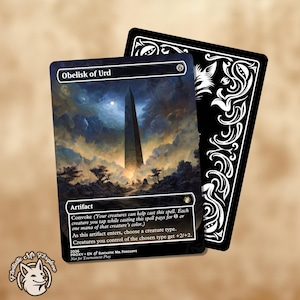 Puede incluir: Una carta de fantasía con el "Obelisco de Urd" con un obelisco oscuro en un paisaje. La carta tiene un borde negro y el texto "Artifact". Una segunda carta con un diseño decorativo en blanco y negro está detrás.