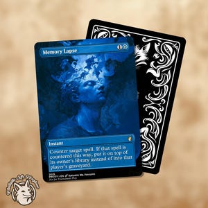 May include: A blue Magic: The Gathering card titled "Memory Lapse" featuring a portrait of a person with blue skin and a dark background. A black card with white ornate designs is behind it. The card has text that reads "Instant" and a description of the spell.