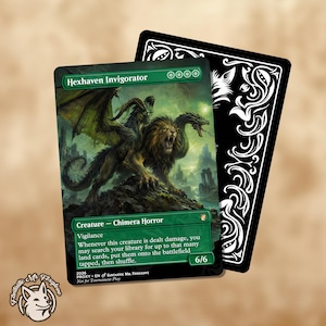 May include: A rectangular trading card titled Hexhaven Invigorator featuring a green border and a central illustration of a multi-headed chimera creature. The card displays the text Creature - Chimera Horror, Vigilance, and game rules, with a black card back featuring white ornate scrollwork patterns.