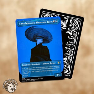 Puede incluir: Una tarjeta azul con el texto "Sakashima of a Thousand Faces" y una ilustración estilizada de una persona con un sombrero grande. La tarjeta también incluye el texto "Legendary Creature - Human Rogue" y "3/1". Una tarjeta negra con remolinos decorativos blancos está detrás de la tarjeta azul.