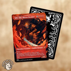 May include: A Kiki-Jiki, Mirror Breaker card with a fiery red and orange background, featuring a goblin shaman. The card has the text "Legendary Creature - Goblin Shaman" and "2/2". A black card with white decorative patterns is behind it.