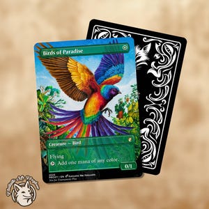May include: A trading card depicting a brightly coloured bird in flight, labelled "Birds of Paradise." The card has a green border and text stating "Creature - Bird" and "Flying." A black card with white decorative patterns is behind it.