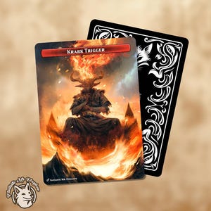 May include: A fantasy card featuring a fiery demon with horns and the text "KRARK TRIGGER." The card's artwork depicts a figure engulfed in flames, with a black card visible behind it. The card has a red banner at the top.