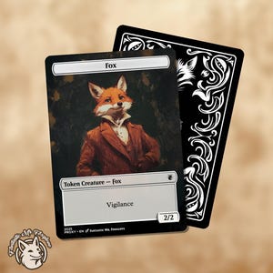 May include: A white card with a black border and a fox illustration. The card has the text "Fox" at the top, "Token Creature - Fox" in the middle, and "Vigilance" below that. The card also has the text "2/2" in the bottom right corner.