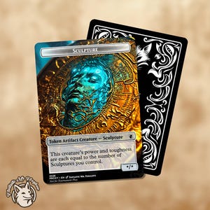 Puede incluir: Una carta coleccionable rectangular que presenta una escultura circular dorada con un rostro azul en el centro. La carta está etiquetada como Sculpture, Token Artifact Creature, e incluye texto que indica que su fuerza y resistencia equivalen al número de Sculptures controladas.
