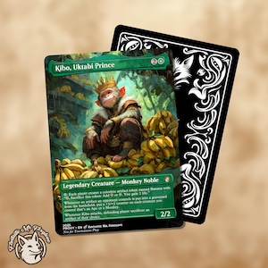 Può includere: Una carta di Magic: The Gathering con "Kibo, Uktabi Prince", una scimmia incoronata, circondata da banane. La carta ha un bordo verde con testo e una forza/resistenza di 2/2. Una carta nera con elementi decorativi bianchi è dietro.