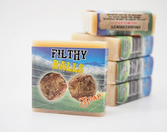 May include: A stack of four bars of soap with a baseball theme. The front bar has a blue background with two baseballs and the text "FILTHY BALLS SOAP".