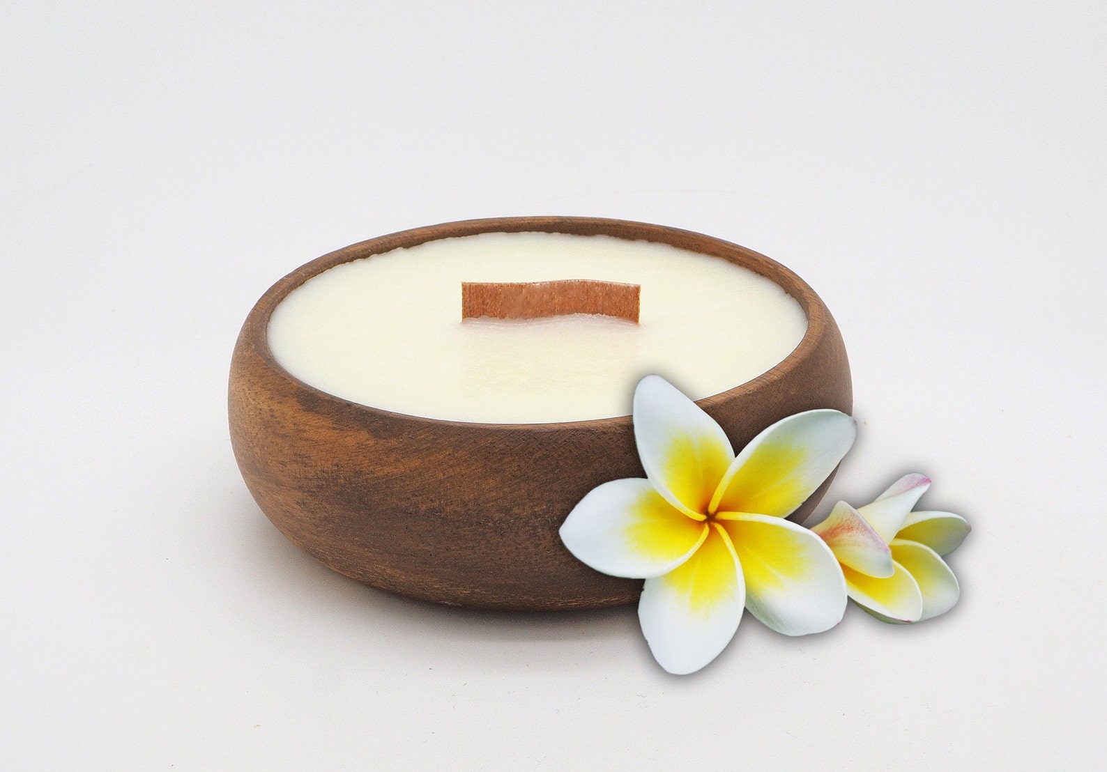 Soy plumeria-scented candle in a coconut shell