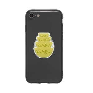 May include: A black smartphone with a pop-up grip featuring a stack of yellow bowls with a floral design. The bowls are in a tiered arrangement, and the grip is attached to the back of the phone.
