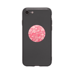 May include: A dark gray smartphone with a pink floral design pop socket. The pop socket features a white floral pattern on a pink background. The phone has a camera lens on the top.