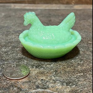 K&ouml;nnte beinhalten: Eine antike gr&uuml;ne Glasschale in Form eines Huhns und eines Nestes. Das Huhn sitzt in einem Nest mit einer kleinen Vertiefung zum Aufbewahren von Butter oder anderen kleinen Gegenst&auml;nden.