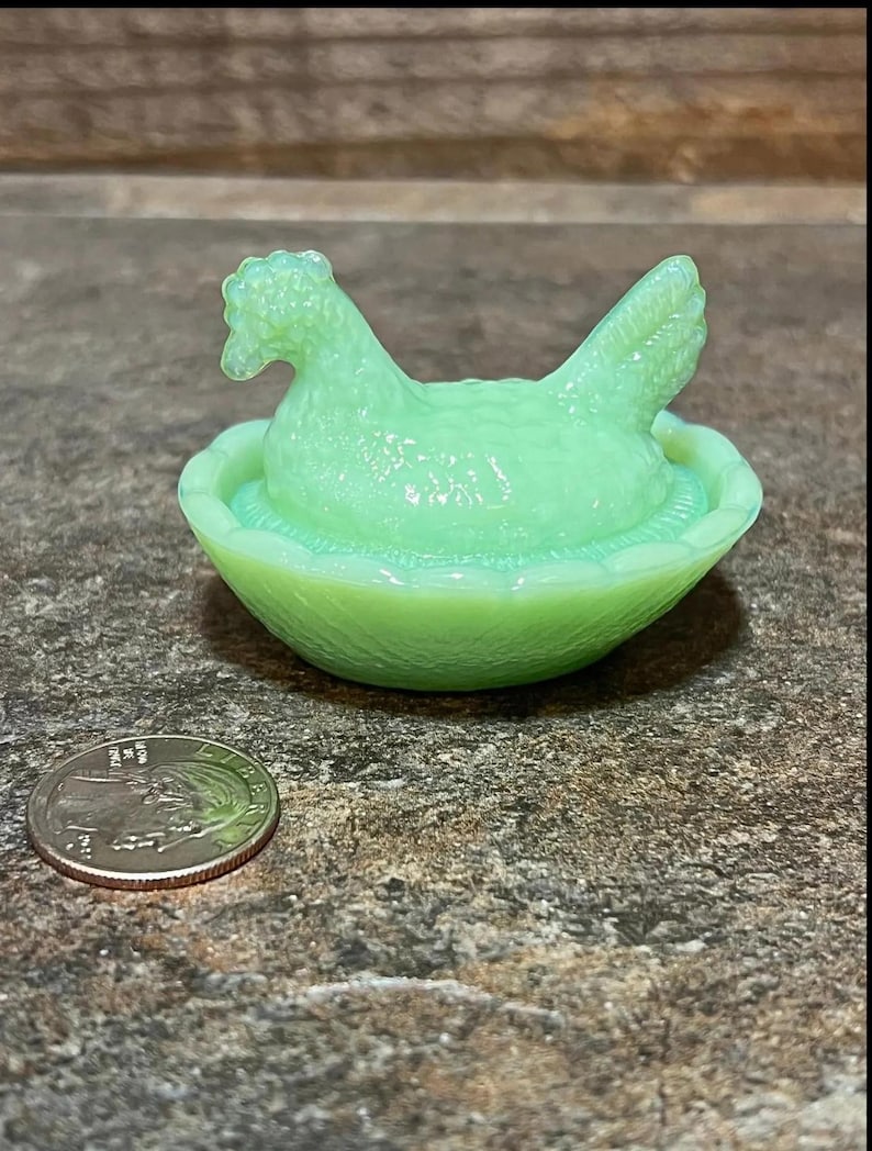 K&ouml;nnte beinhalten: Eine antike gr&uuml;ne Glasschale in Form eines Huhns und eines Nestes. Das Huhn sitzt in einem Nest mit einer kleinen Vertiefung zum Aufbewahren von Butter oder anderen kleinen Gegenst&auml;nden.