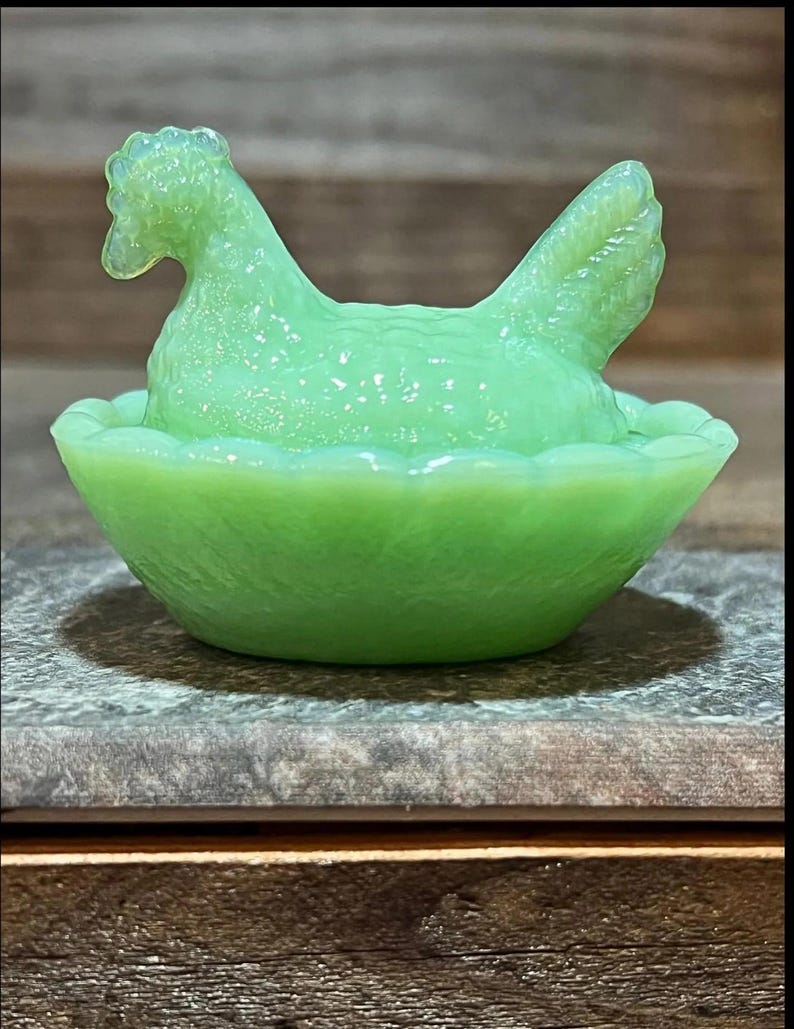 K&ouml;nnte beinhalten: Eine gr&uuml;ne Glasschale in Form eines Huhns mit einem Nest. Die Schale ist aus Depressionsglas und ein Vintage-Artikel.