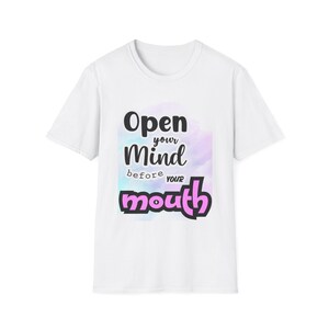 May include: White t-shirt with a colorful background and the text "Open your mind before your mouth" in black and pink.
