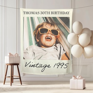 May include: A personalized photo banner with the text "THOMAS 30TH BIRTHDAY" at the top and "Vintage 1995" at the bottom. The banner features a photo of a child wearing sunglasses. White balloons and a gift box are also present.